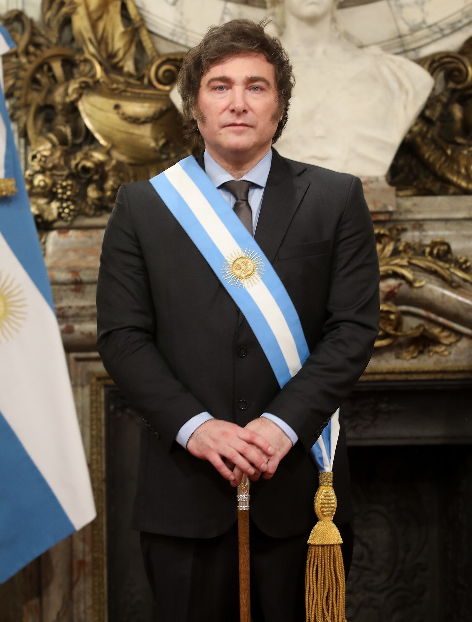 Un trabajador con overol camina frente a la entrada cerrada de una empresa estatal en Buenos Aires